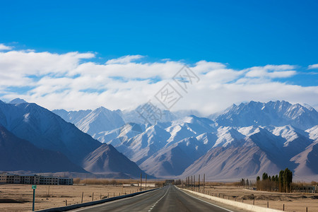 蓝天下的公路和远处的雪山背景图片