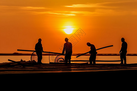 夕阳下劳动的工人背景图片