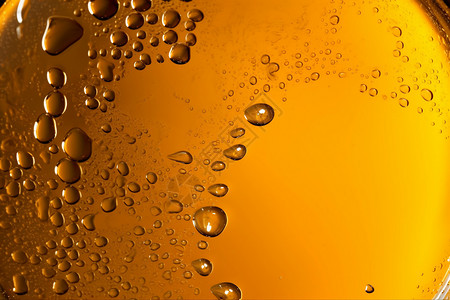 玻璃杯黄色啤酒抽象气泡创意背景设计图片