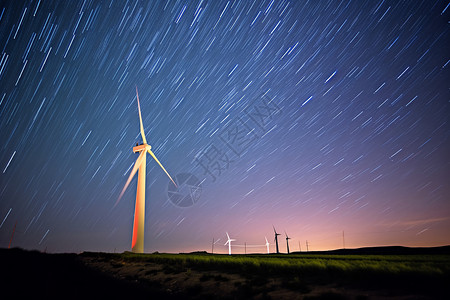 夜晚星空下的风力涡轮机背景图片