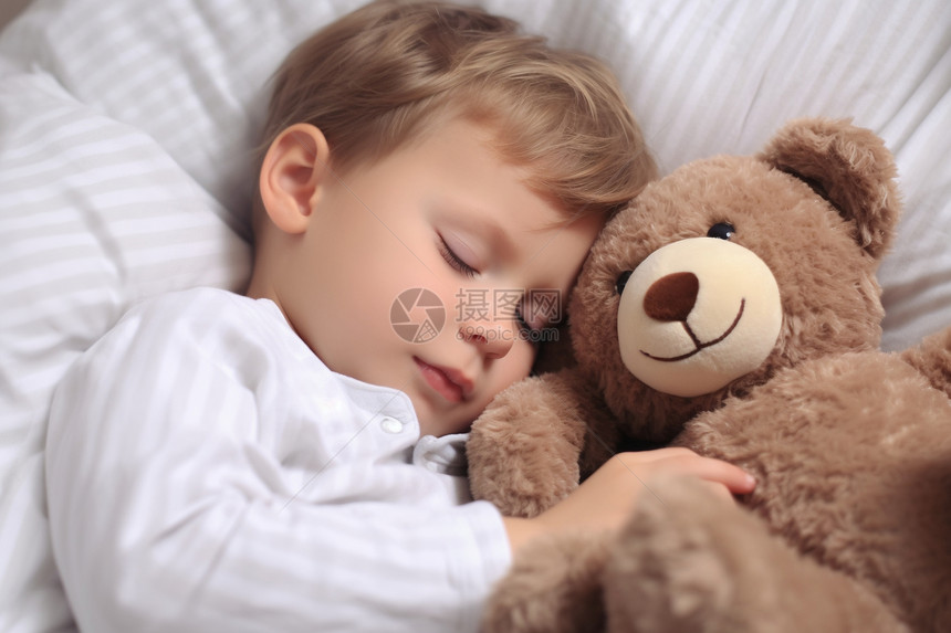 抱着玩偶睡着的小男孩图片