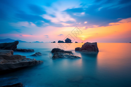蔚蓝岩石字效日落下蔚蓝的大海背景