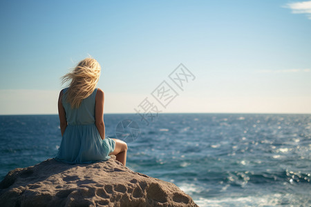坐在岩石上的女孩背景图片