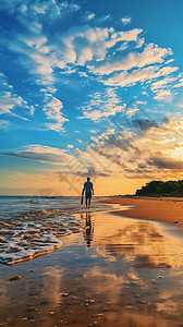 日落时沙滩上散步的男子图片