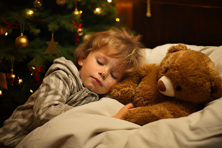 抱着泰迪熊入睡的小男孩背景图片