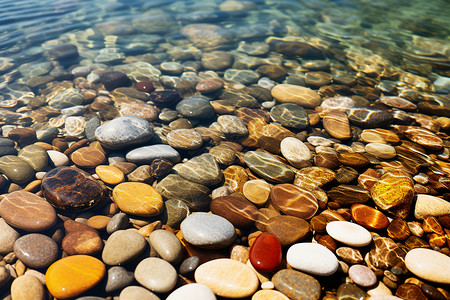 岸边湖水中一堆石头背景图片