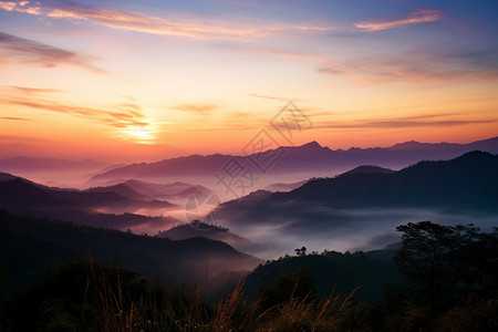 日出时迷雾笼罩的山脉景观图片