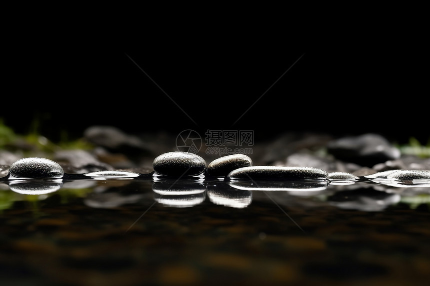 水滴飞溅下的黑色石头图片