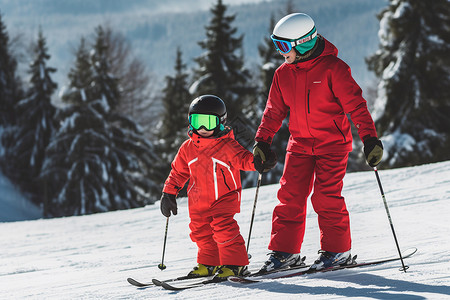 陪伴孩子滑雪的母亲高清图片