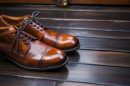 一双棕色鞋子在木地板上背景图片