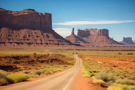 公路穿越沙漠与山脉背景图片