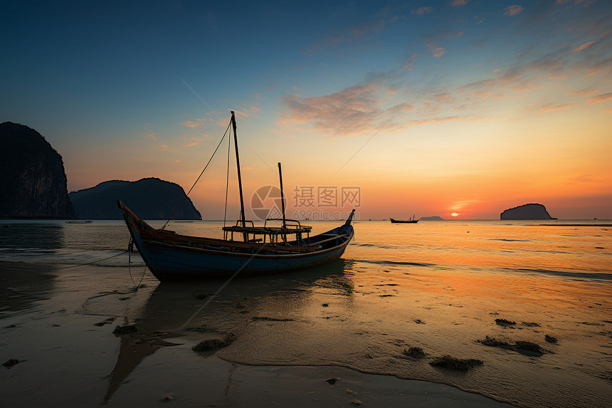 日出或日落时的海滩上停着一艘船图片