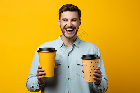 快乐的男子举着纸杯在黄色背景墙前拍照图片