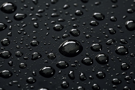 滴落水珠水滴在黑色表面上的特写照设计图片