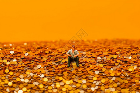 一个小人坐在金币上图片