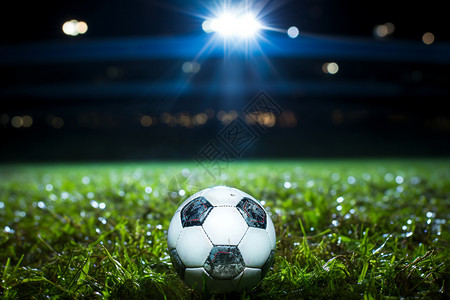 夜晚草地上的足球背景图片