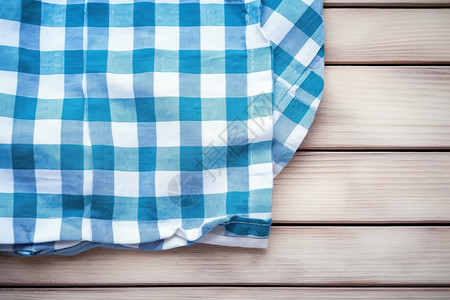 木质桌面的蓝白格子毯子背景图片