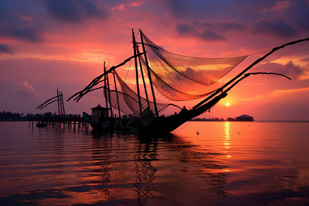 捕网日落时水面上的渔船背景