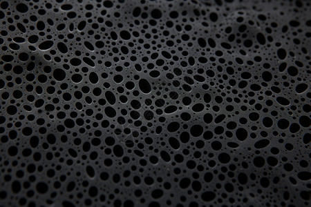 黑色海绵黑色泡沫墙壁上的小洞背景
