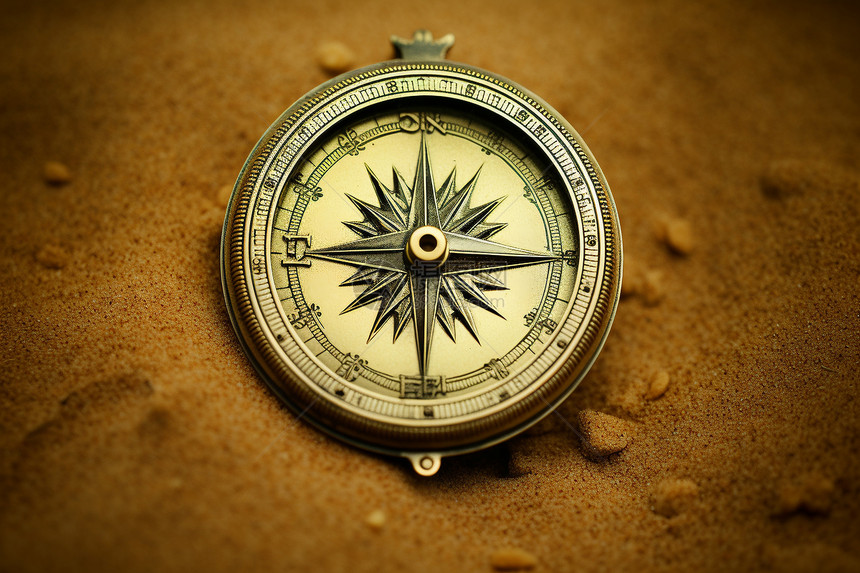 沙丘中的黄铜指南针图片