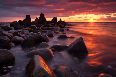 夕阳余晖下的黑色礁石图片