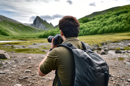 山脉中举着相机的男性背景图片
