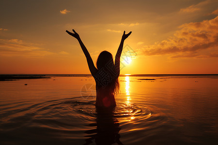 女士剪影海边的女子夕阳下张开双臂背景