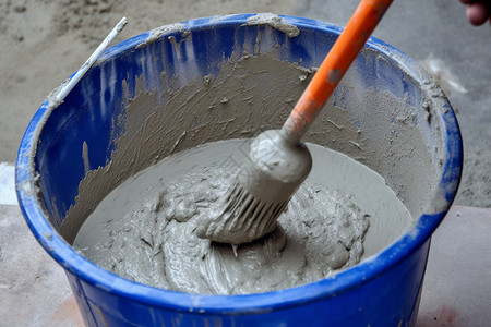 桶中搅拌的水泥涂料高清图片