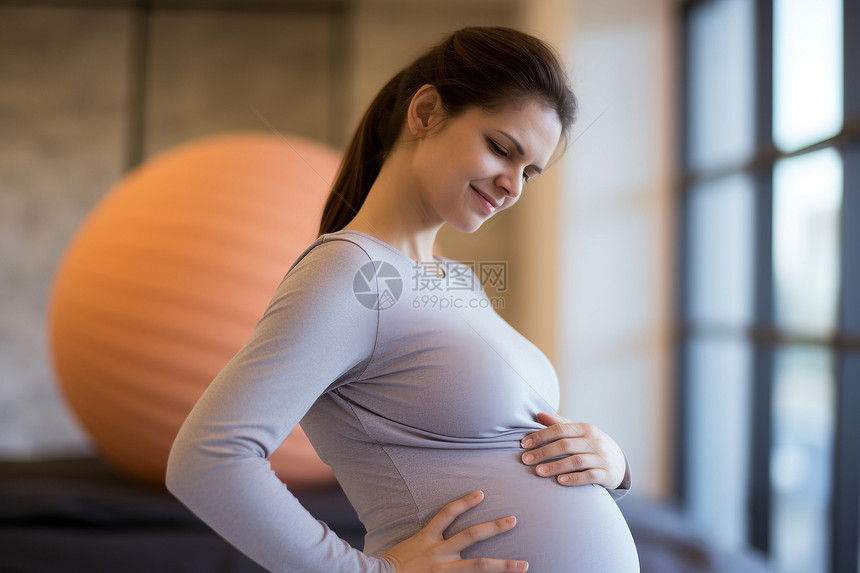 一个孕妇用手扶着肚子图片