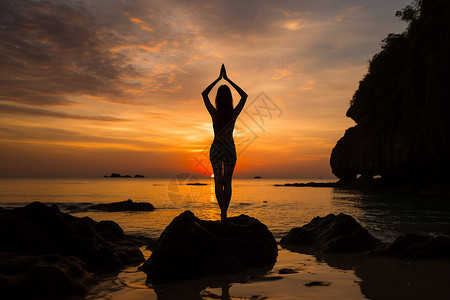 黄昏瑜伽女士站在海边岩石上做瑜伽背景