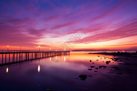 紫色夕阳下的海边码头背景图片