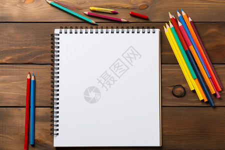 木桌上的笔记本和彩笔背景图片