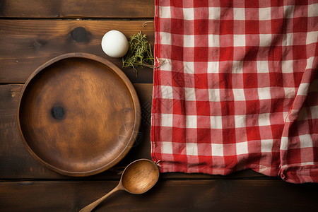 木质餐桌上的红白格子桌布背景图片