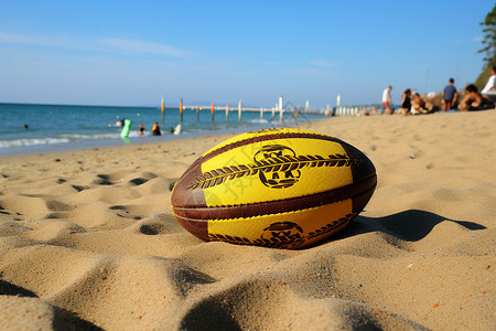 沙滩上的黄褐色橄榄球背景图片