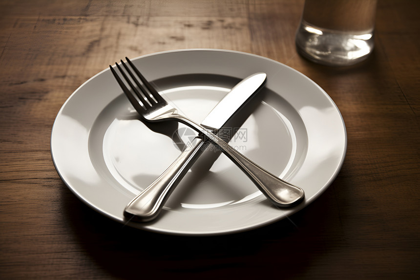 餐桌上的白瓷盘子与刀叉图片