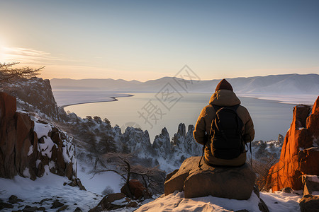 雪山中观看日出的男子背景图片