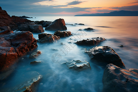 日出时的岩石海滩背景图片
