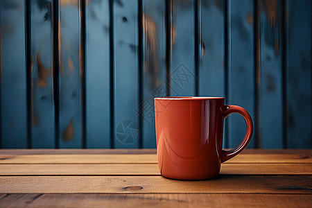 木桌蓝墙旁的咖啡杯背景图片