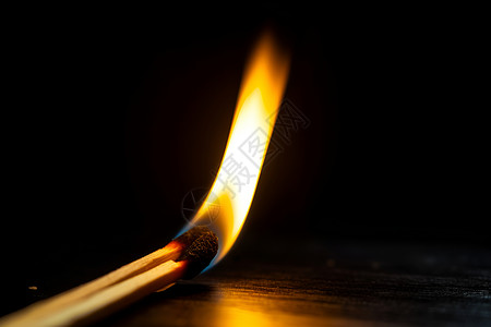 黑暗中点燃的火柴背景图片
