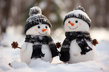 两个雪人在雪地中带着帽子背景图片