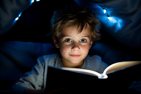 夜晚阅读书本的小男孩背景图片