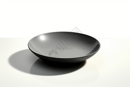 白碟白桌面上的黑碗背景