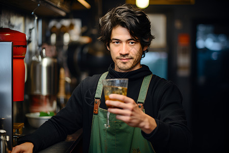 穿着绿色围裙的男人，端着一杯啤酒背景图片