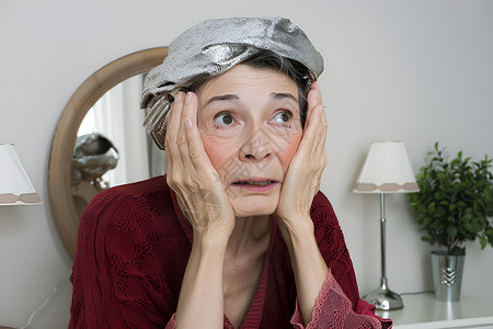 美容背景模版老年女子戴帽子目瞪口呆地看着相机背景有一面镜子背景