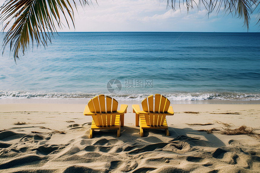 沙滩上两把黄色躺椅图片