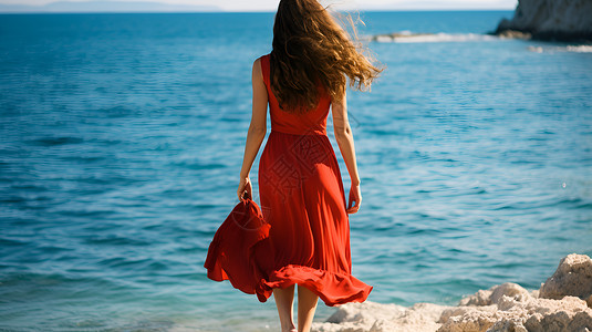 红衣女郎在沙滩上漫步高清图片